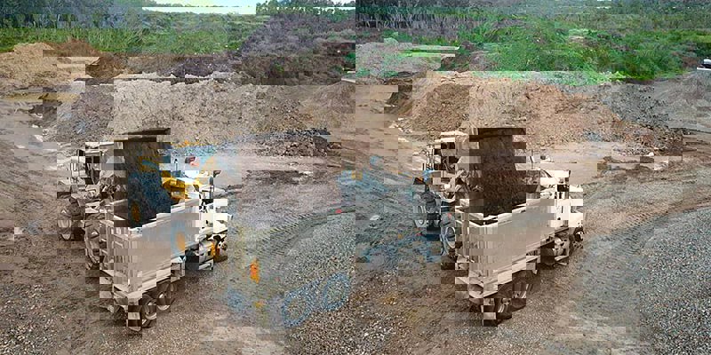 loader truck loading premium soil into tipper truck
